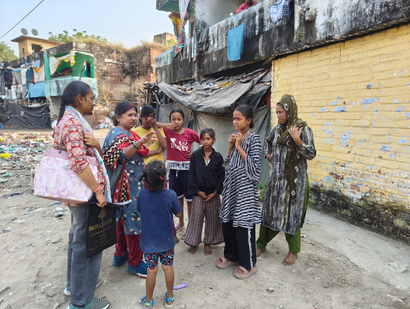 Children and women in a slum community before Sanrakshan's support